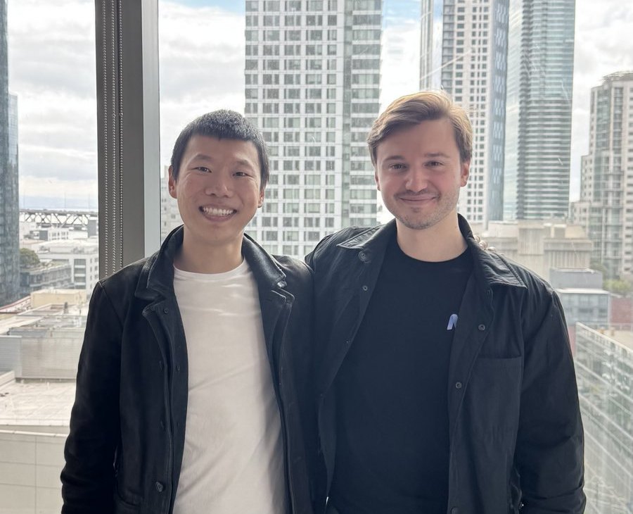 The photo attached to Edward Hu's September 1 announcement that he is joining Mercor: two people standing at an office window with the San Francisco skyline behind them